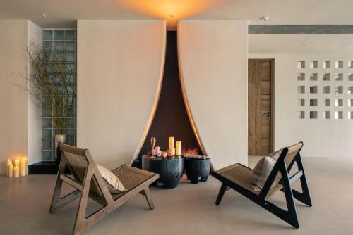 a living room with two chairs and a fireplace at Wild Persimmon Manor Cove Mist Healing Hot Spring in Anji