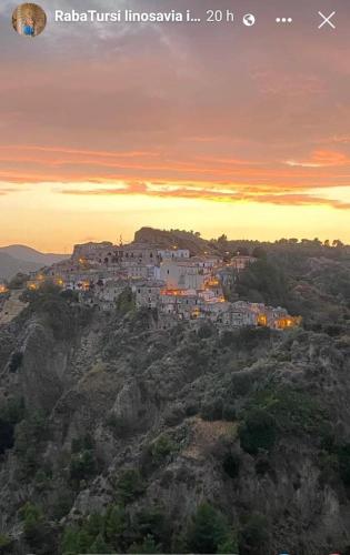 a village on top of a mountain at sunset at Palazzo dei Poeti in Tursi