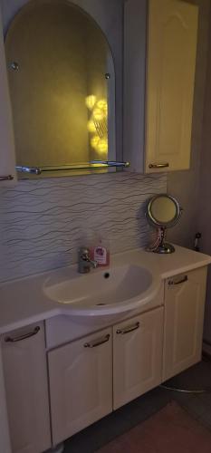 a bathroom with a white sink and a mirror at Viihtyisä saunallinen rivitalokolmio in Alatornio