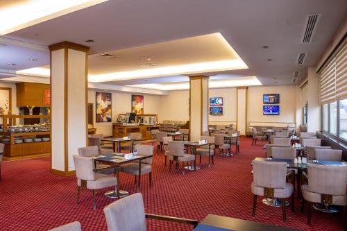 a restaurant with tables and chairs in a room at Anemon Grand Eskişehir Otel in Eskisehir