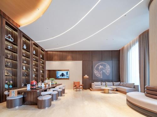 a rendering of a hotel lobby with tables and chairs at 东莞塘厦高铁南站锦江都城酒店 in Lincun