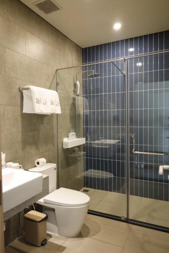 a bathroom with a toilet and a glass shower at Lá Riverside Boutique Hotel in Mỹ Phước