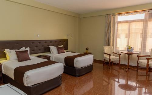 a hotel room with two beds and a table at Maxland Hotel in Nairobi