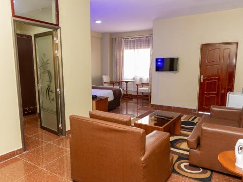 a living room with a couch and a room with a bed at Maxland Hotel in Nairobi