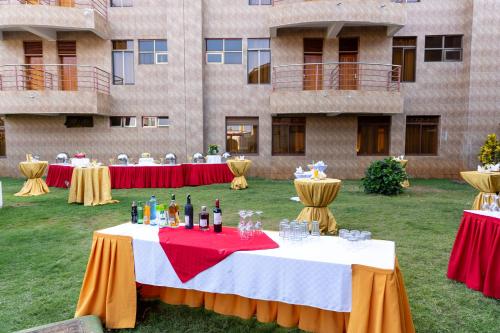 a table with bottles of wine on it in front of a building at Maxland Hotel in Nairobi
