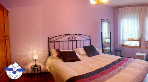 a bedroom with a large bed with purple walls at Altur 5 Canfranc Estación in Canfranc-Estación