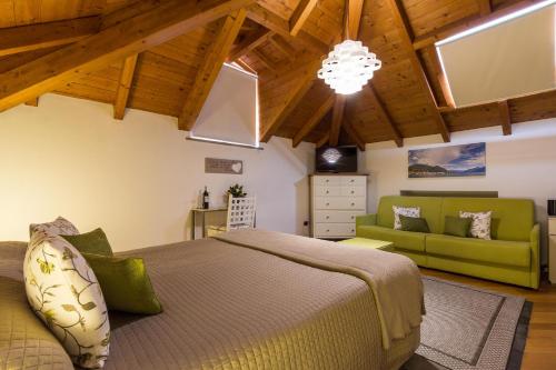 a bedroom with a bed and a green couch at La Villa vacation home Lake Como in Como