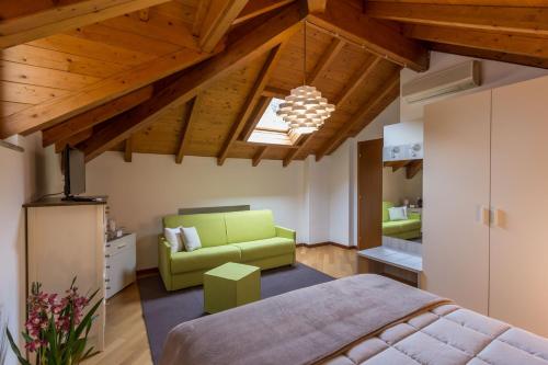 a bedroom with a green bed and a couch at La Villa vacation home Lake Como in Como
