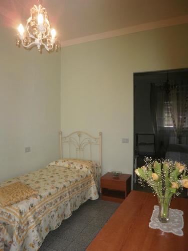 a bedroom with a bed and a vase of flowers on a table at BeB Angelini dal 1911 in Lucca