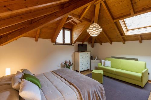 a bedroom with a large bed and a green couch at La Villa vacation home Lake Como in Como