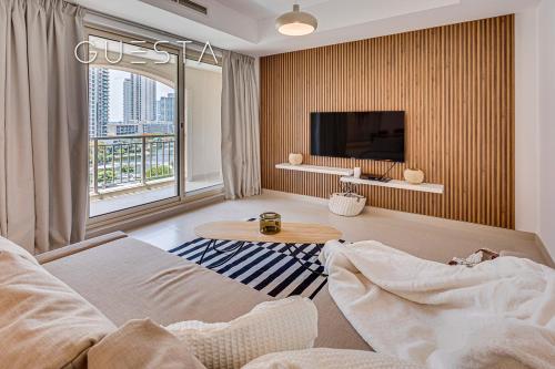a living room with a couch and a tv at The Views & Greens - Mosela Tower, Dubai in Dubai