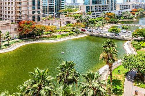 a body of water with palm trees and buildings at The Views & Greens - Mosela Tower, Dubai in Dubai