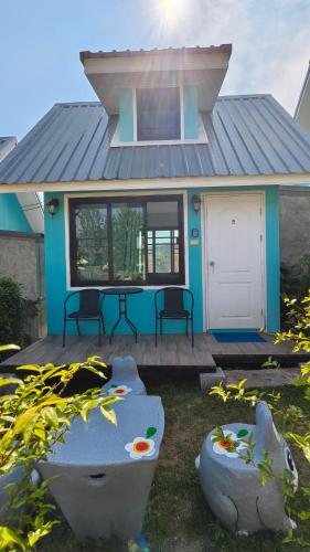 a blue house with two chairs and a patio at โซพราว เขาค้อ So Proud Khaokho in Khao Kho