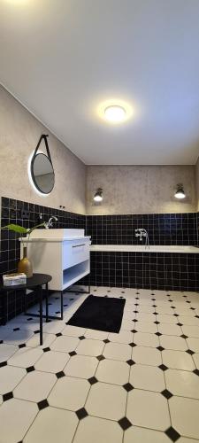 ein Badezimmer mit Waschbecken und schwarz-weißen Fliesen in der Unterkunft Brücke26 Stadthaus mit Dachterrasse in Mühlhausen