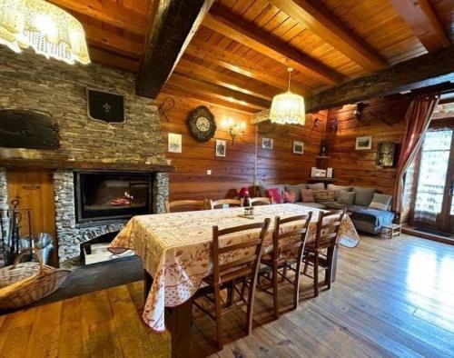 une salle à manger avec une table et une cheminée dans l'établissement Maison de montagne chez Baptiste, à Ascou