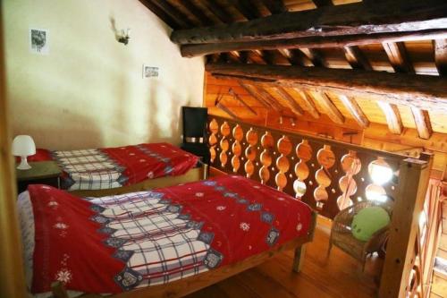Cette chambre comprend 2 lits avec des couettes rouges. dans l'établissement Maison de montagne chez Baptiste, à Ascou