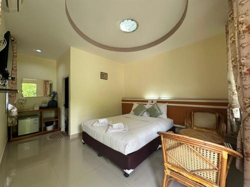 a bedroom with a bed with a clock on the ceiling at ชอว์ งาทอง รีสอร์ต Chor Ngar Thong Erawan Kanchanaburi in Kanchanaburi