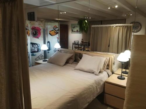 Un dormitorio con una gran cama blanca con dos lámparas. en Villa Lilli, en La Asomada