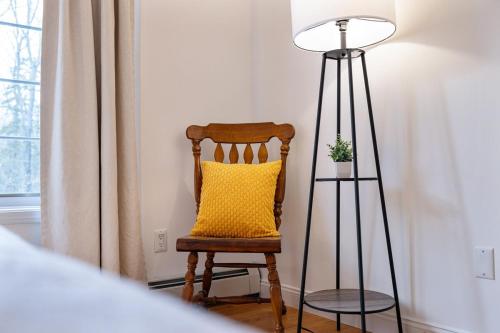 a yellow pillow on a wooden chair next to a lamp at Secluded 9BR Getaway, Pool, Hot Tub & Huge Deck in Chester