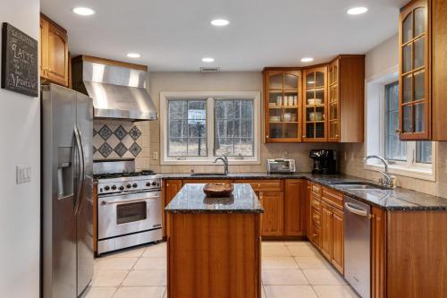 a kitchen with wooden cabinets and stainless steel appliances at Secluded 9BR Getaway, Pool, Hot Tub & Huge Deck in Chester