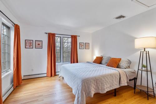 a white bedroom with a bed and orange curtains at Secluded 9BR Getaway, Pool, Hot Tub & Huge Deck in Chester