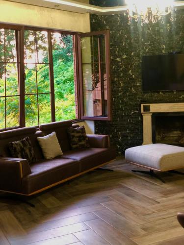 a living room with a couch and a fireplace at Villa Kolkhi in Kvariati