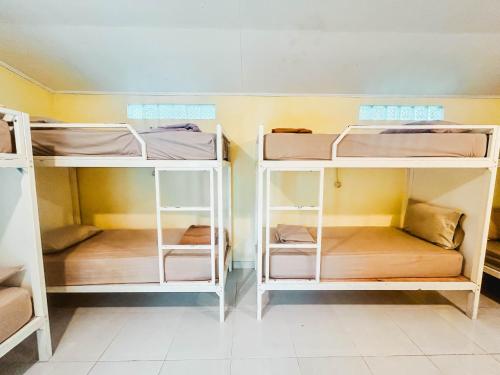 a room with three bunk beds in a room at Rinjani Garden Syariah by ecommerceloka in Sembalun Lawang