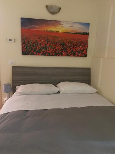 a bedroom with a bed with a painting on the wall at Ca' Rossa in Roe