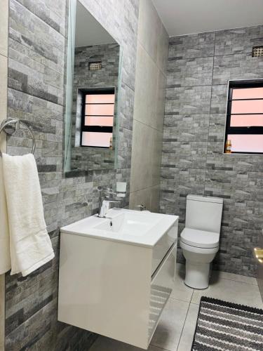 a bathroom with a white sink and a toilet at Zaidi Luxury Home in Secunda