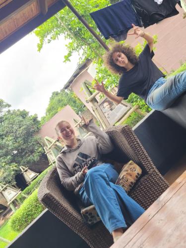 two people sitting on a chair with their skateboards at Lusaka Backpackers in Lusaka