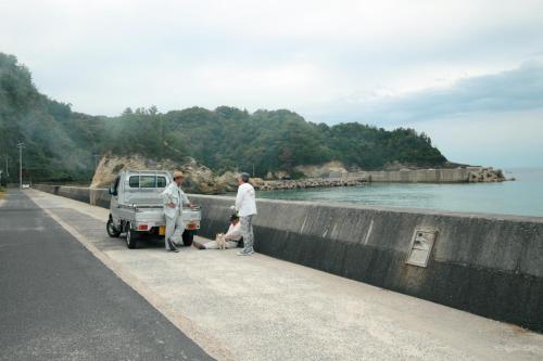 a group of people standing next to a truck on a road at HÏSOM 湯里 in Oda