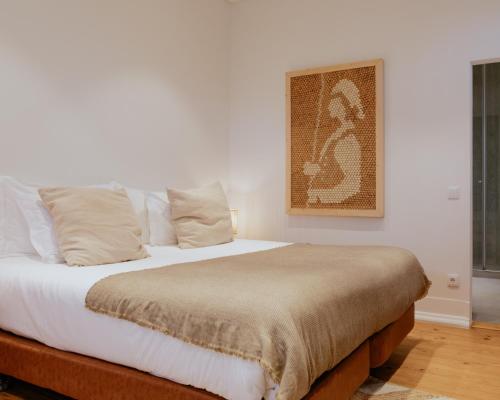 a bed in a bedroom with a picture on the wall at A Casa Brava in Santarém