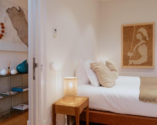 a bedroom with a bed with white sheets and pillows at A Casa Brava in Santarém