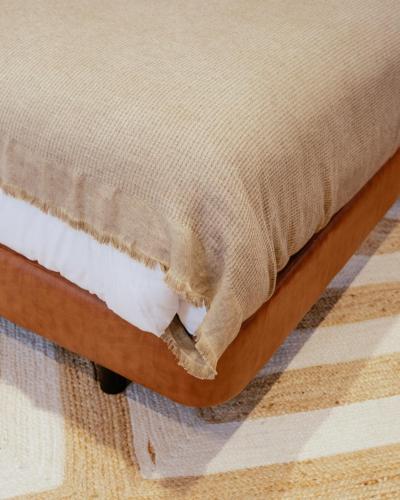 a bed frame with a blanket on top of it at A Casa Brava in Santarém
