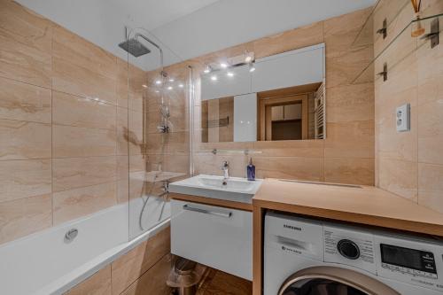 a bathroom with a washing machine and a sink at HUGE APARTMENT next to train station close to the city center in Staré Mesto
