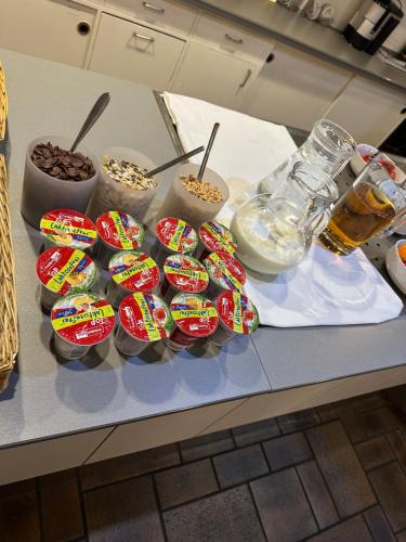 a counter with a bunch of cupcakes and bowls of food at Hotel Hellers Twenty Four I -24h-Check-In- in Friedrichshafen