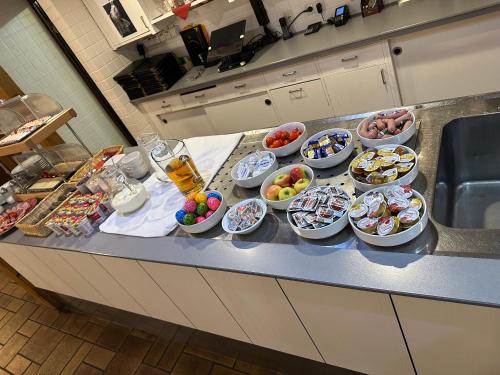 a kitchen counter with many bowls of food on it at Hotel Hellers Twenty Four I -24h-Check-In- in Friedrichshafen