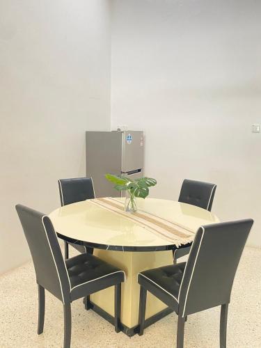 a table with four chairs and a plant on it at 8 pax KakaHomestay Tmn Petani Jaya in Sungai Petani