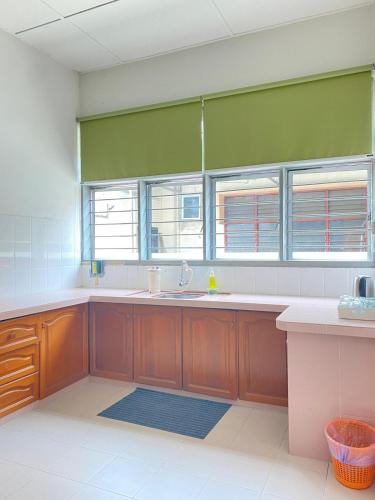 a large kitchen with a sink and two windows at 8 pax KakaHomestay Tmn Petani Jaya in Sungai Petani