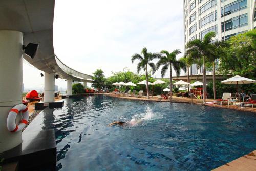 a person swimming in a pool at a hotel at Centara Grand At CentralWorld in Bangkok