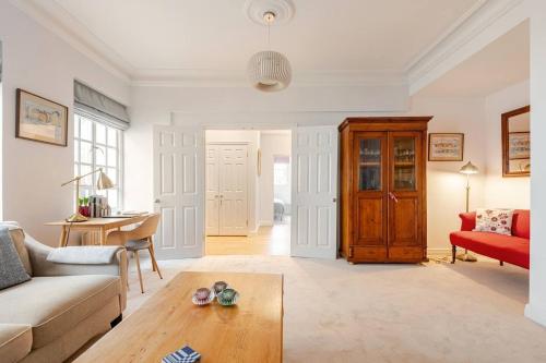 ein Wohnzimmer mit Sofa und Tisch in der Unterkunft Nordic Regency Apartment in Cheltenham