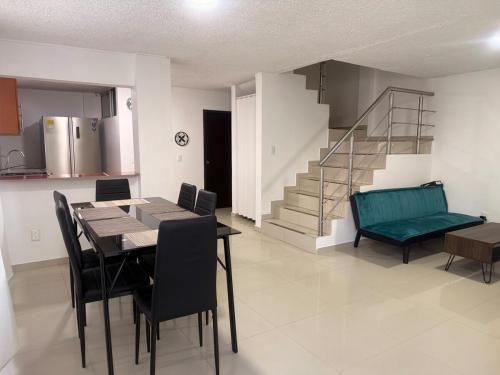 a dining room with a table and chairs and a staircase at Habitación pequeña a una cuadra de Ventura Plaza in Cúcuta
