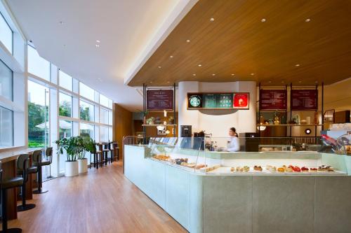 a restaurant with a counter and a person in a kitchen at Centara Grand At CentralWorld in Bangkok