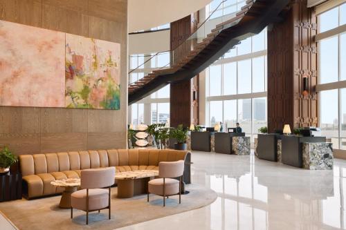 a lobby with a couch and chairs and a table at Centara Grand At CentralWorld in Bangkok