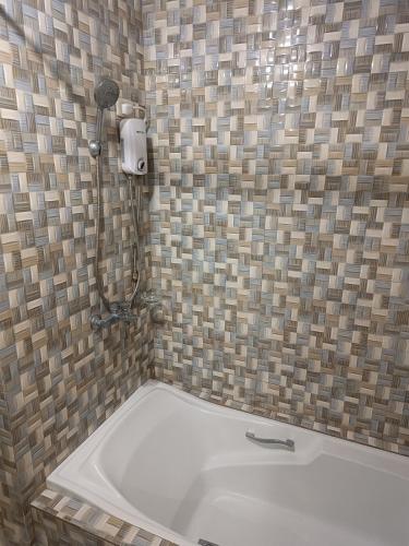 a shower in a bathroom with a bath tub at Spacious modern home near town in Baguio