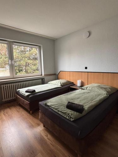 a bedroom with two beds and a window at Case One Monteur Aparthotel in Mülheim an der Ruhr