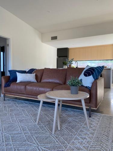 a living room with a brown couch and a table at The Pavilion at Sevenhill in Penwortham