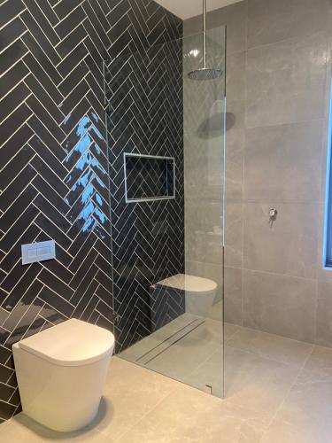 a bathroom with a toilet and a glass shower at The Pavilion at Sevenhill in Penwortham