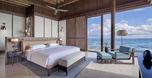 a bedroom with a bed and a view of the ocean at Park Hyatt Maldives Hadahaa in Gaafu Alifu Atoll