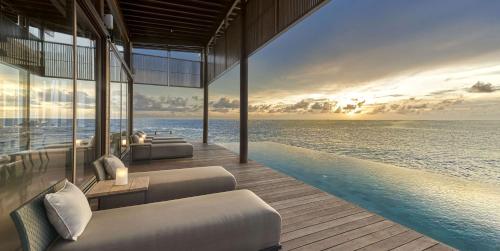 a pool with a view of the ocean at sunset at Park Hyatt Maldives Hadahaa in Gaafu Alifu Atoll